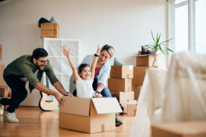 Carefree family having fun while moving into new home Family packing moving boxes together using self storage packing tips.