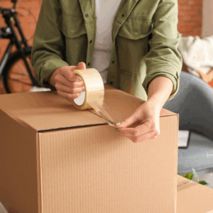 ProStorageSelfStorageTips West Henly Storage Person packing and taping a cardboard box for storage