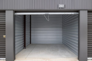 Empty West Henly self-storage unit with open roll-up door showing interior space.