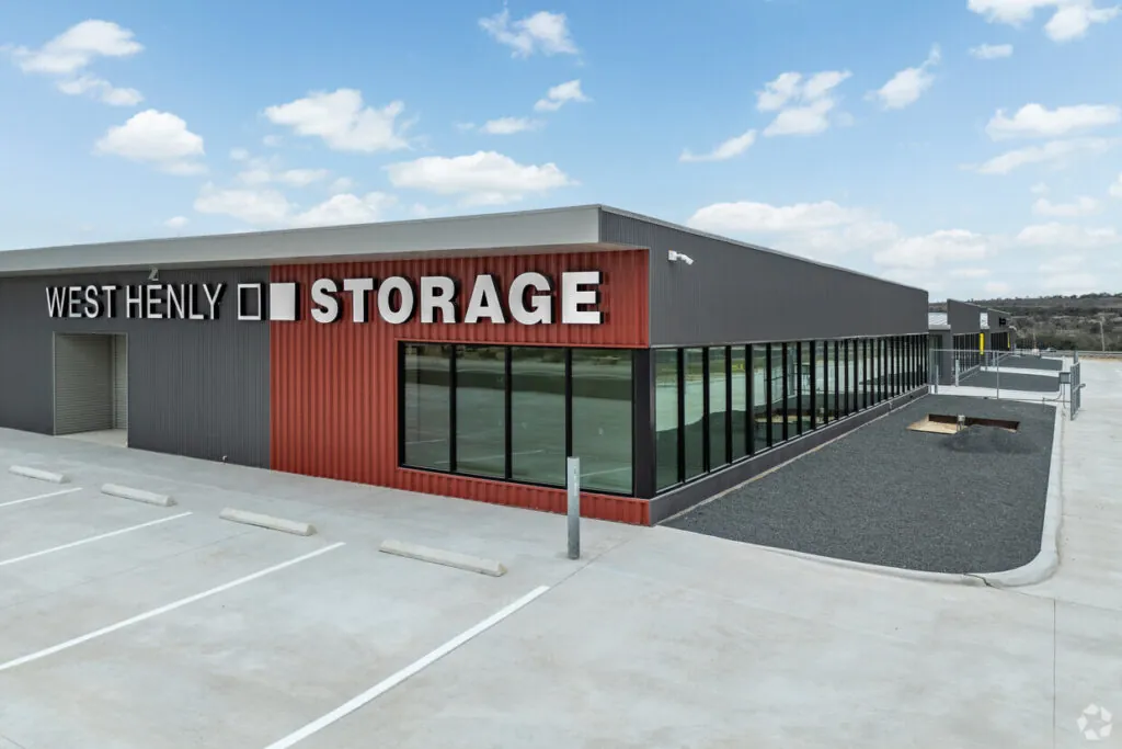 West-Henly-Self-Storage-Facility-Main-Office-in-Johnson-city-Texas Exterior view of West Henly Storage facility with office entrance and storage units.