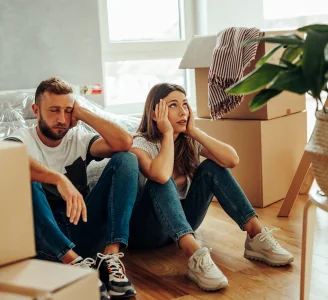 faqs West Henly Storage A couple sitting among moving boxes with questions about storage